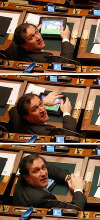 L'onorevole Roberto Menia gioca con l'I-Pad mentre il centrosinistra fa ostruzionismo e accortosi di essere fotografato cerca di nascondere il tablet, in aula della Camera