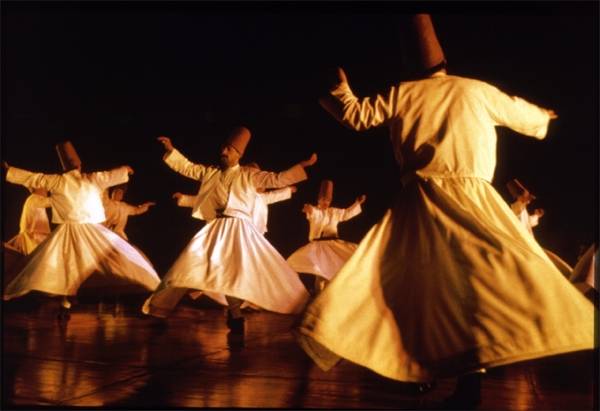 i dervisci, monaci islamici sufi, danzano girando vorticosamente con i loro abiti di lana bianca, le ampie gonne e un cono di feltro rosso in testa