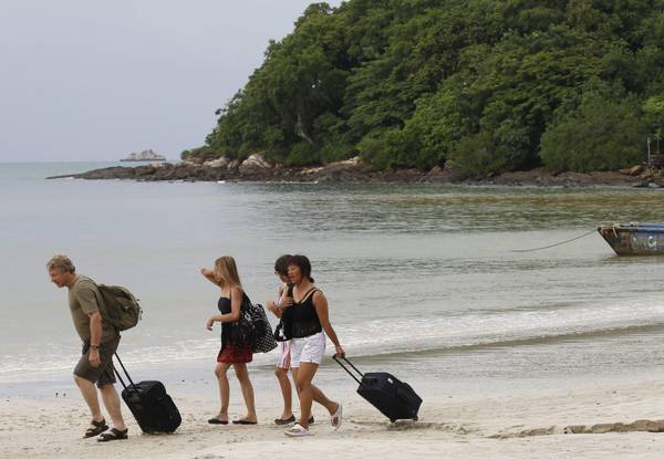 Turisti lasciano la spiaggia di  Samet Island