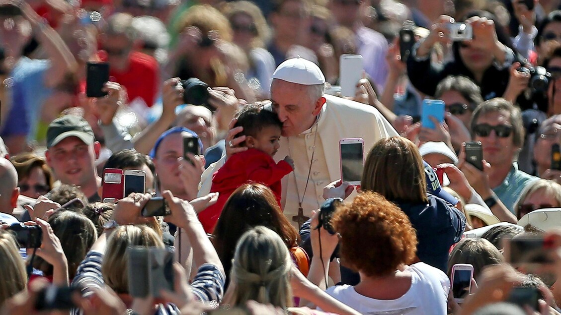 Papa Francesco bacia un bimbo durante l'Udienza generale a piazza san Pietro