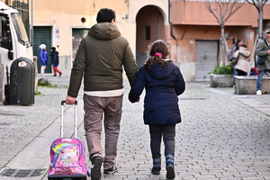 Genitori e figli verso la scuola (ANSA)