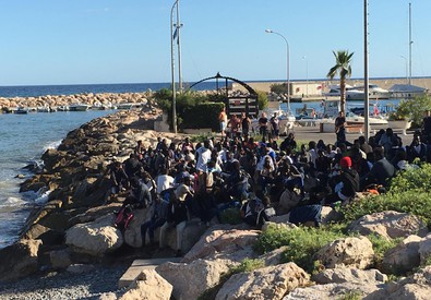 Un gruppo di migranti occupa gli scogli a Menton Garavan (ANSA)