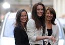 Kate Middleton sorride ai fotografi la sera prima del matrimonio insieme alla sorelal Pippa e alla madre Carole