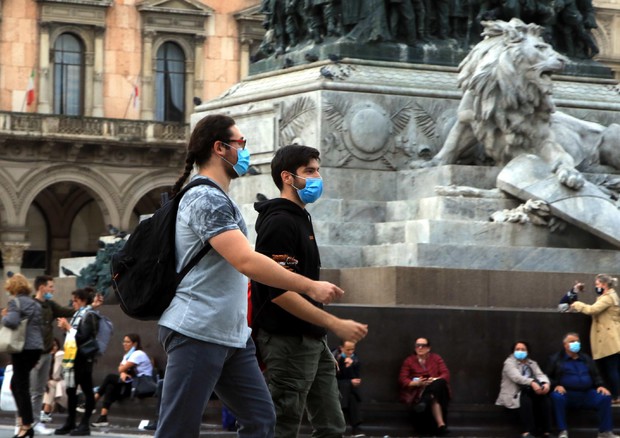 Persone passeggiano indossando la mascherina © ANSA