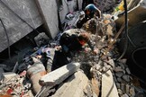 Palestinians remove bodies from the rubble of a building hit by an Israeli strike in Beit Lahia