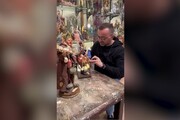 Garcia con valigia di cartone nella bottega dei presepi a San Gregorio Armeno