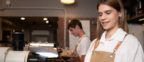 Una giovane barista prepara un cappuccino foto iStock.