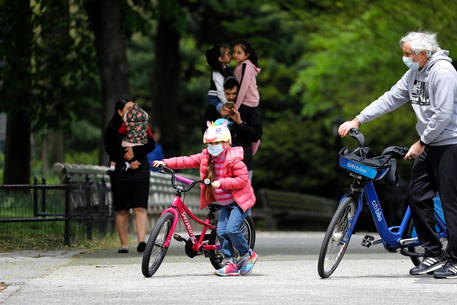 Bambina in bici nel parco con il padre (foto Ansa) © EPA