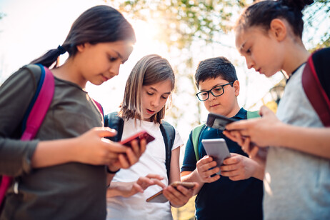 Studenti intenti a guardare telefonini foto iStock.