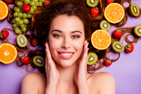Una donna sorridente su un letto di frutta foto iStock.