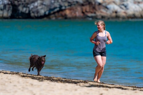 Una giovane corre sulla spiaggia foto unsplash