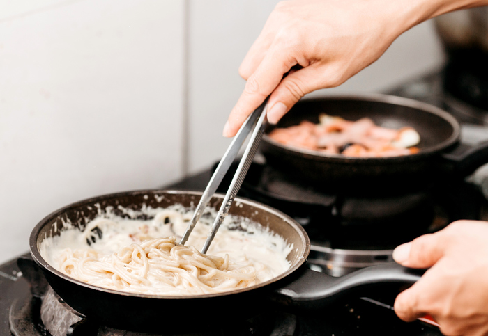 Vista dall'alto bollire la pasta istantanea coreana o spaghetti in padella  rossa, attività di cucina casalinga