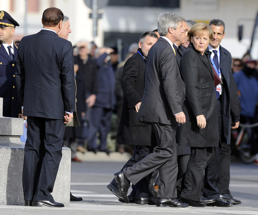 Il presidente del Consiglio Silvio Berlusconi fa 'cucu', nascosto dietro uno dei grandi lampioni, alla cancelliera tedesca Angela Merkel a Trieste in occasione del vertice  bilaterale italo-tedesco, il 18 novembre 2008