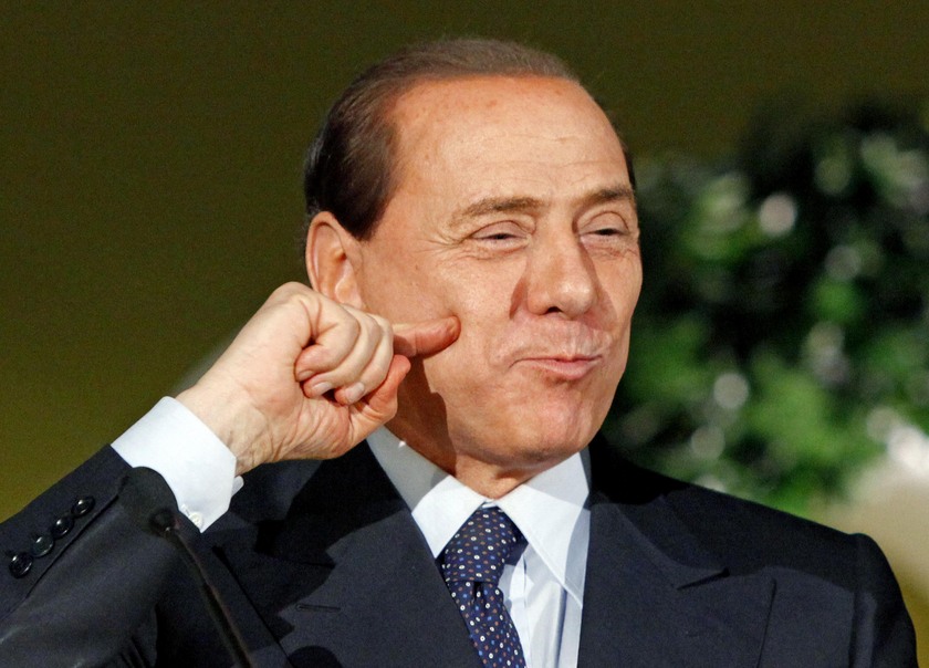 Silvio  Berlusconi fa il gesto di squisito per esprimere apprezzamento dopo aver mangiato stuzzichini  di carne di maiale italiana.