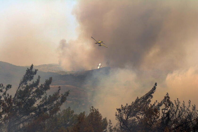 Gli aerei dei vigili del fuoco lanciano acqua per spegnere un incendio nel villaggio di Asklipio © ANSA/EPA