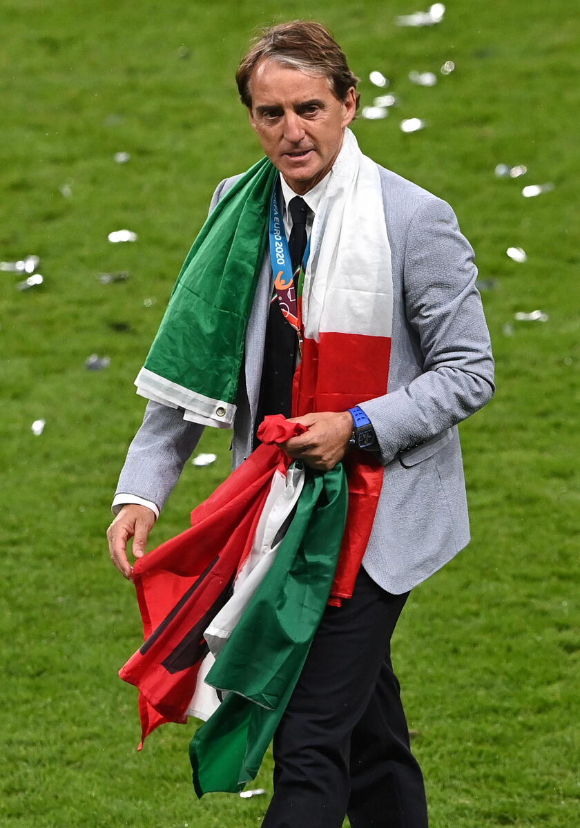 Mancini avvolto dalla bandiera italiana dopo la finale dell 'Europeo vinta a Londra - RIPRODUZIONE RISERVATA