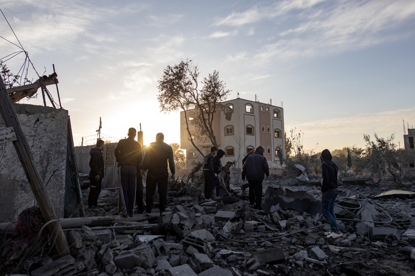 Palestinians inspect the remains of destroyed buildings in Khan Younis