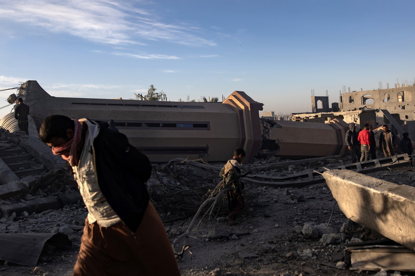 Palestinians inspect the remains of destroyed buildings in Khan Younis