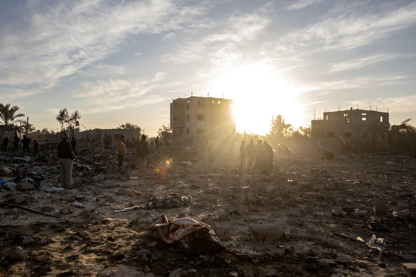 Palestinians inspect the remains of destroyed buildings in Khan Younis