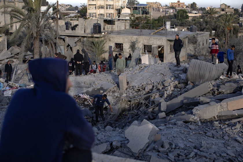 Palestinians inspect the remains of destroyed buildings in Khan Younis