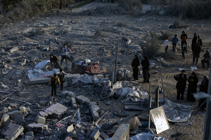 Palestinians inspect the remains of destroyed buildings in Khan Younis