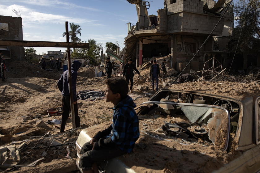 Palestinians inspect the remains of destroyed buildings in Khan Younis