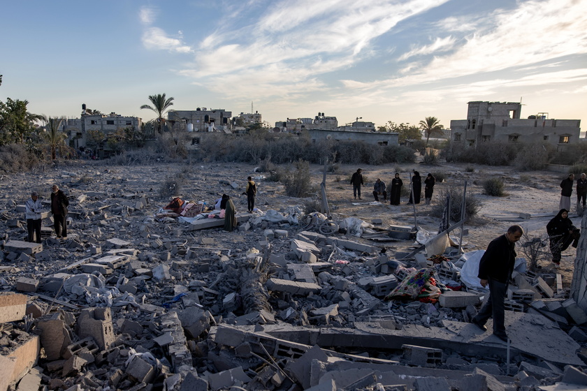 Palestinians inspect the remains of destroyed buildings in Khan Younis