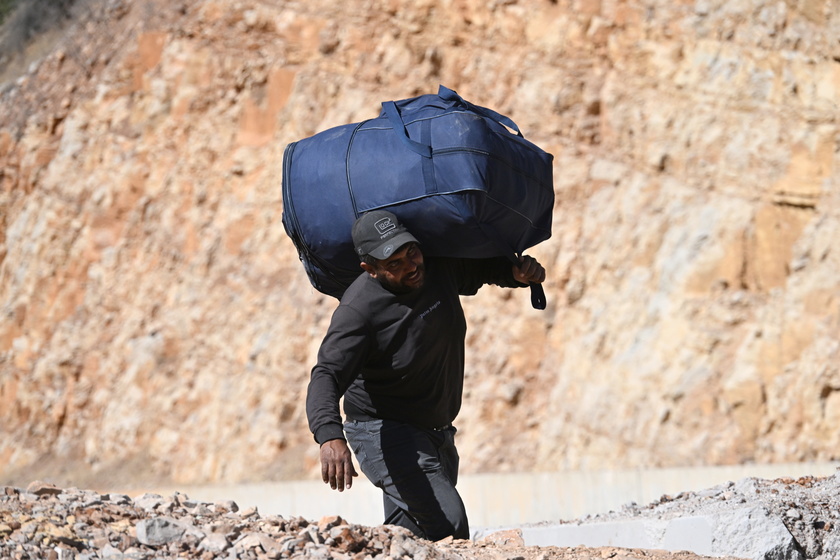 People walk at Masnaa border crossing damaged by Israeli military strike in Lebanon