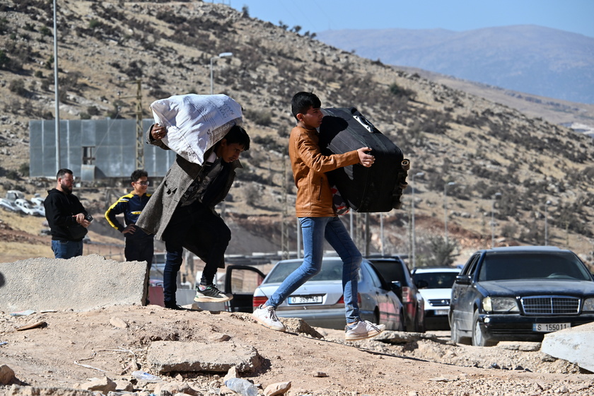 People walk at Masnaa border crossing damaged by Israeli military strike in Lebanon