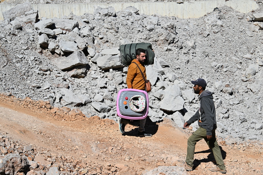 People walk at Masnaa border crossing damaged by Israeli military strike in Lebanon