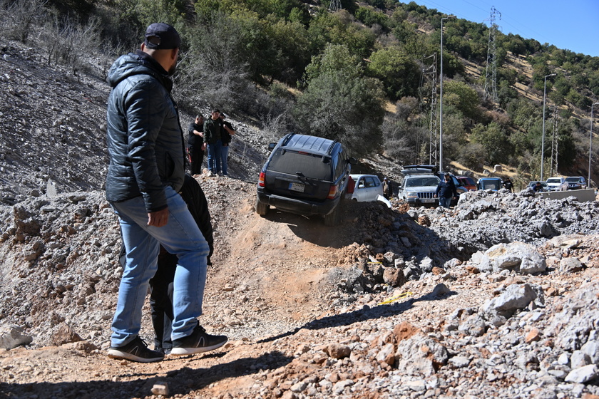 People walk at Masnaa border crossing damaged by Israeli military strike in Lebanon