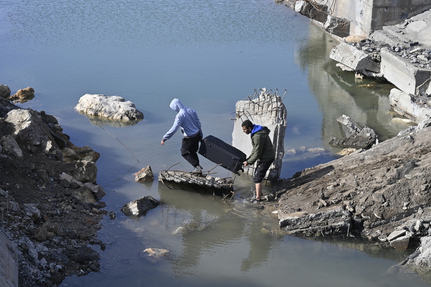 People cross the destroyed Arida border crossing between Syria and Lebanon 