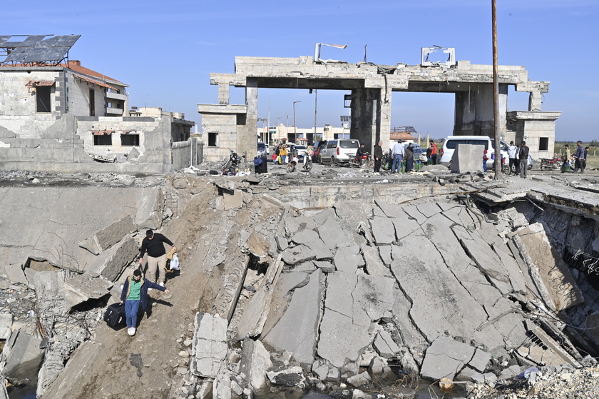 People cross the destroyed Arida border crossing between Syria and Lebanon 