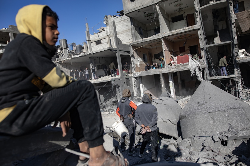 Un ragazzo osserva i danni di un attacco israeliano a Rafah - RIPRODUZIONE RISERVATA