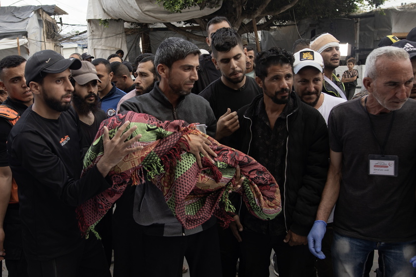 Palestinians mourn their dead after Israeli air strikes on central Gaza