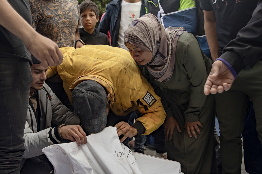 Palestinians mourn their dead after Israeli air strikes on central Gaza