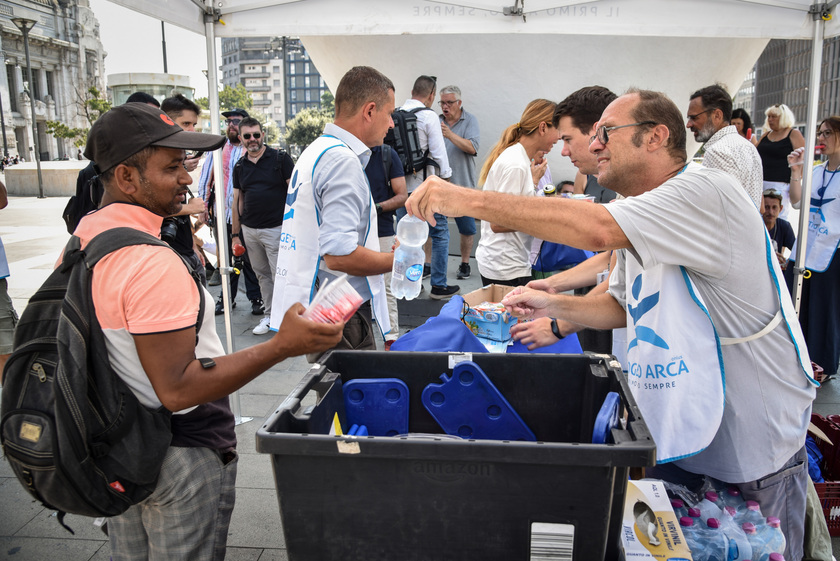 Distribuzione di anguria e ghiaccioli ai senzatetto davanti alla Stazione Centrale da parte dei volontari del Progetto Arca