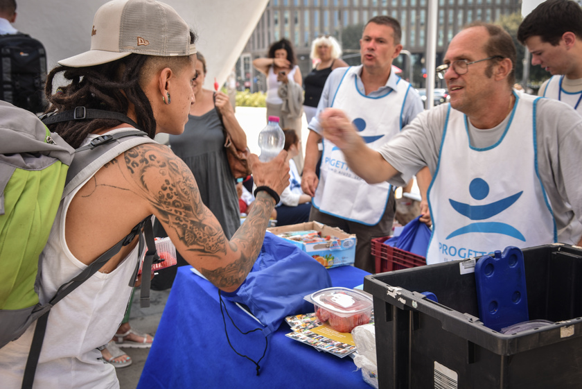 Distribuzione di anguria e ghiaccioli ai senzatetto davanti alla Stazione Centrale da parte dei volontari del Progetto Arca