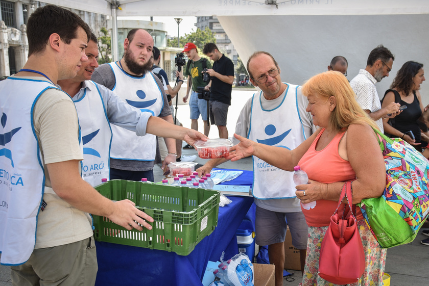 Distribuzione di anguria e ghiaccioli ai senzatetto davanti alla Stazione Centrale da parte dei volontari del Progetto Arca