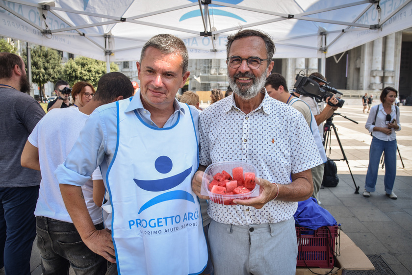 Distribuzione di anguria e ghiaccioli ai senzatetto davanti alla Stazione Centrale da parte dei volontari del Progetto Arca