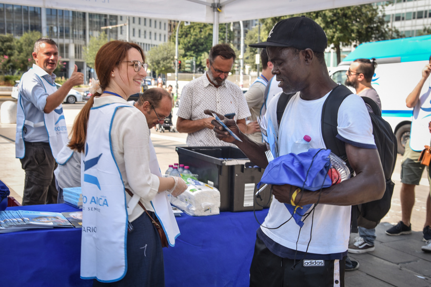 Distribuzione di anguria e ghiaccioli ai senzatetto davanti alla Stazione Centrale da parte dei volontari del Progetto Arca