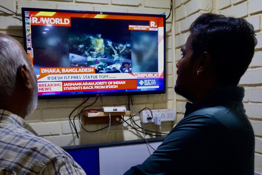 Indian people watch the news on Bangladesh following the prime minister's resignation