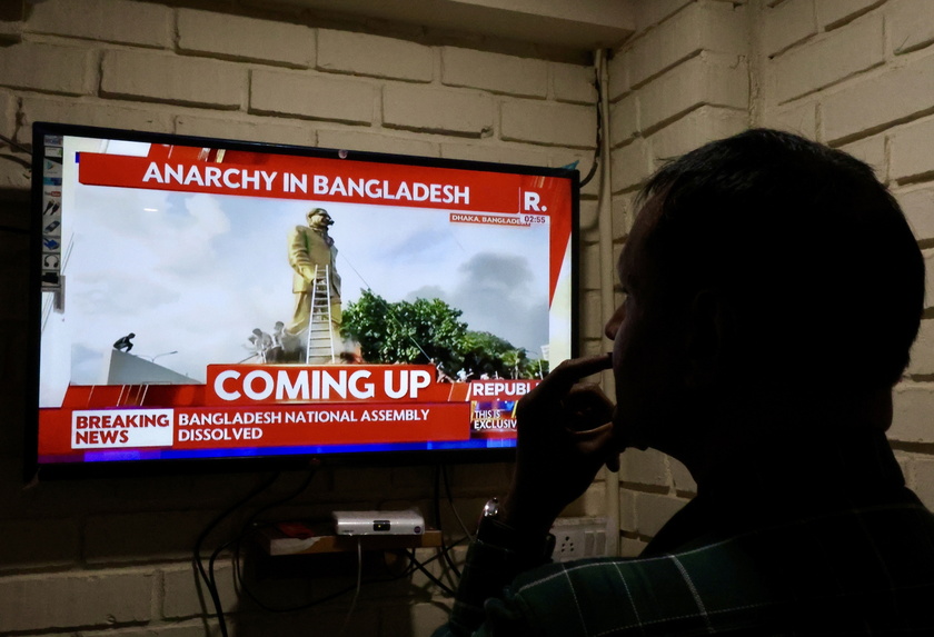 Indian people watch the news on Bangladesh following the prime minister's resignation