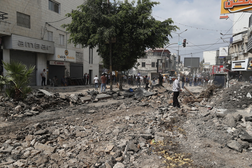 Palestinians inspect the damage after a 10-day Israeli military operation in West Bank's Jenin