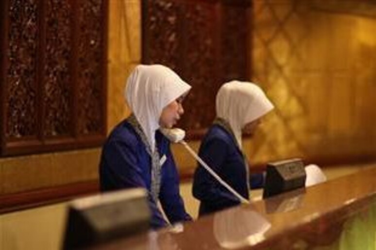 Receptionists con velo islamico in un hotel - RIPRODUZIONE RISERVATA