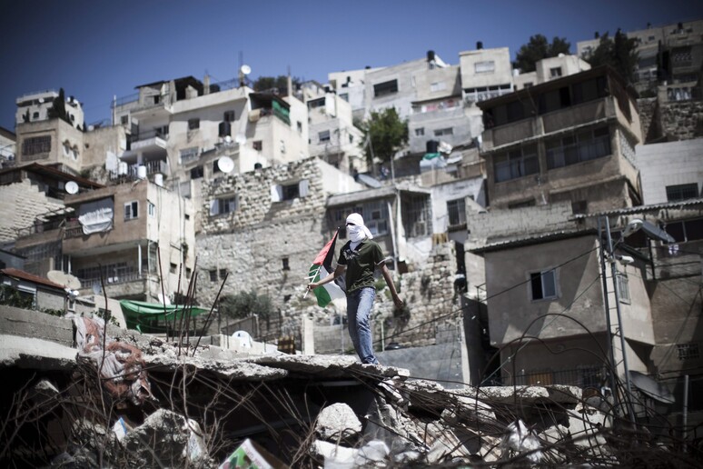 Un giovane con la bandiera palestinese durante una manifestazione contro gli insediamenti ebraici nel quartiere a maggioranza palestinese di Silwan, a Gerusalemme est (foto archivio) -     RIPRODUZIONE RISERVATA