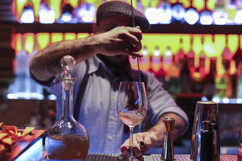 Un barman al lavoro in una foto di archivio - RIPRODUZIONE RISERVATA