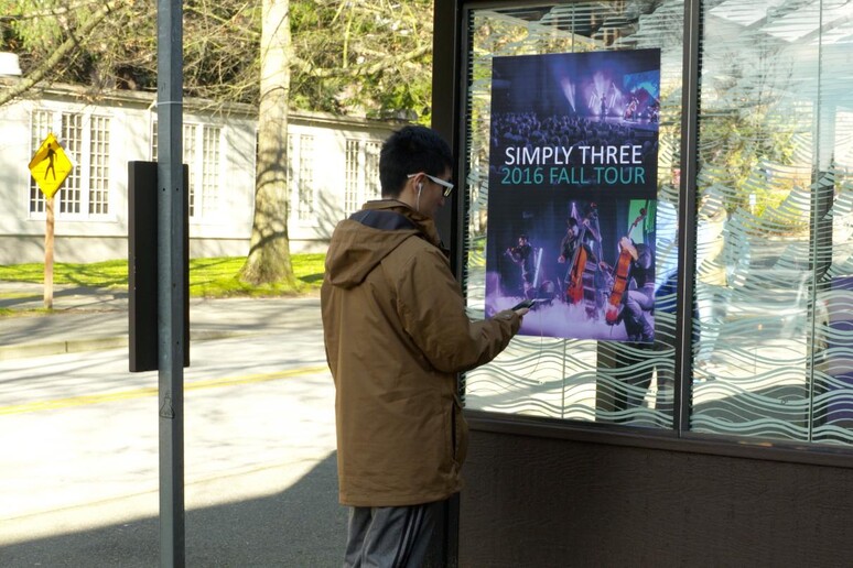 Uno degli ingegneri dell 'Università di Washington usa segnali radio FM scaricando i dati da un poster alla fermata di un autobus a Seattle (fonte: University of Washington) - RIPRODUZIONE RISERVATA