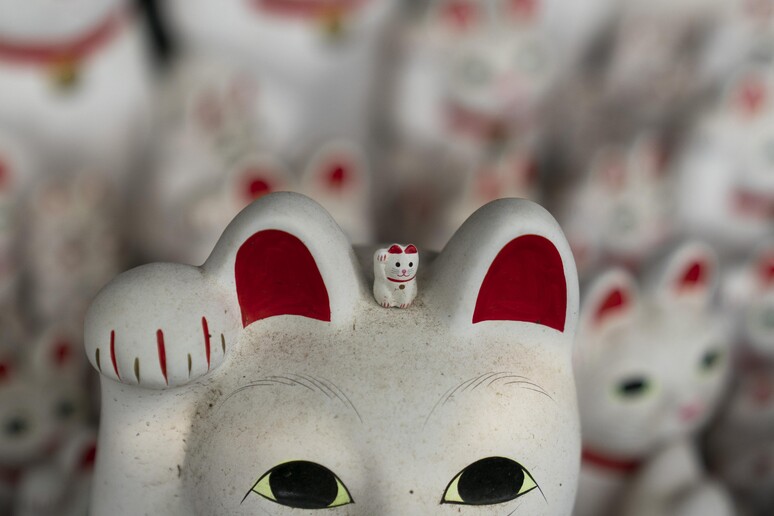 Il gatto Maneki-Neko è una statua culturale tradizionale del Giappone che  si crede porti grande ricchezza e fortuna al suo proprietario. Traduzione:  'Entra Foto stock - Alamy