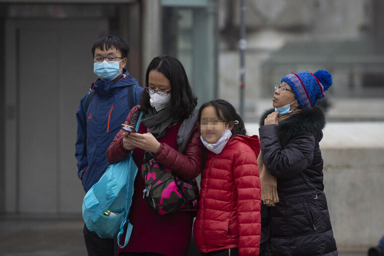 Cittadini asiatici con la mascherina come precauzione contro il virus - RIPRODUZIONE RISERVATA